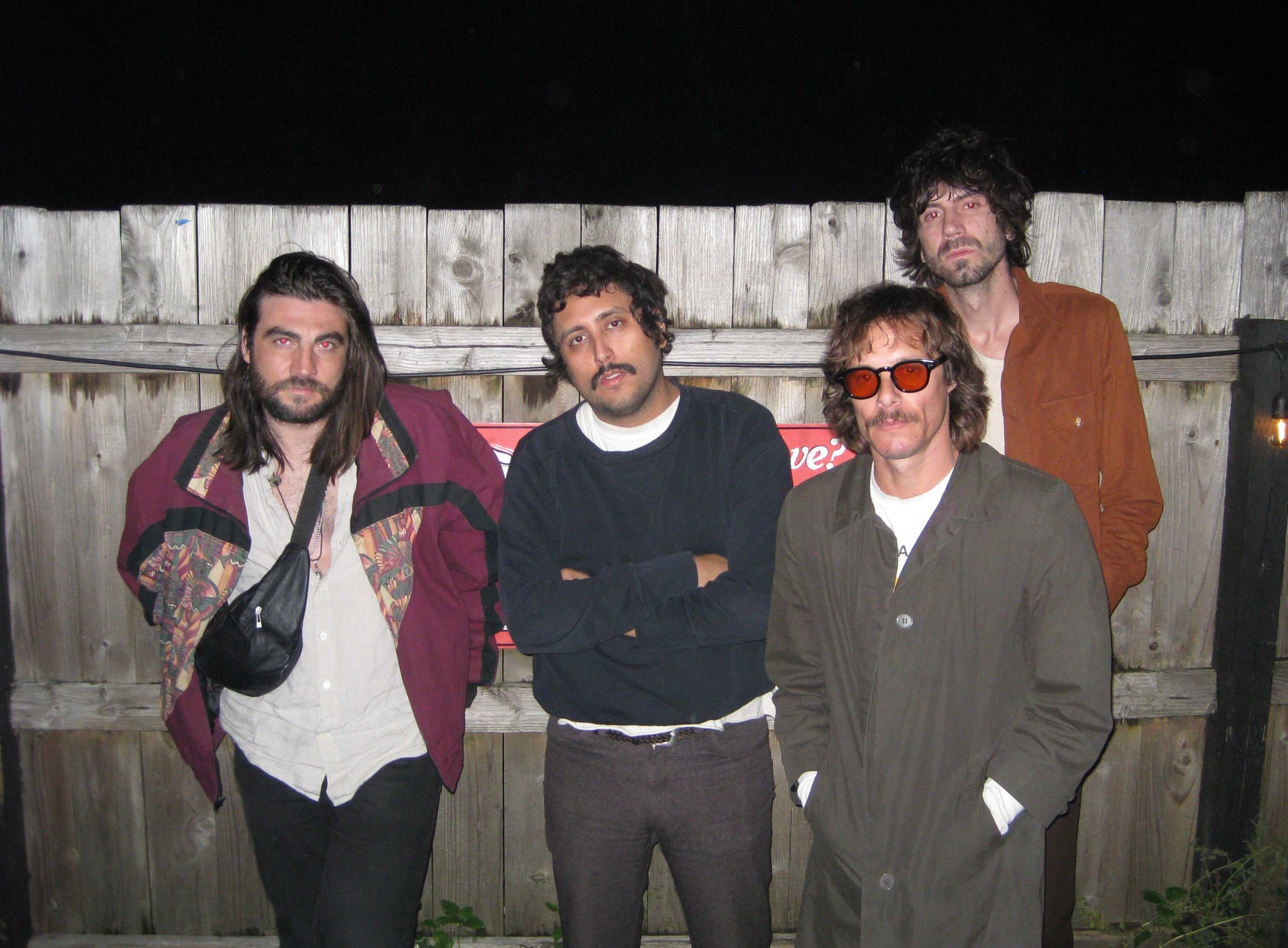 4 men posing in front a fence, they are the band members fr the band Windows.