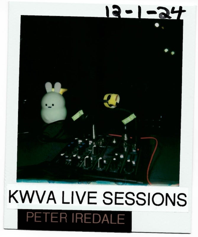 Dark polaroid photo reading "KWVA Live Sessions Peter Iredale 12-2-24 with a small audio mixer and bunny light on a desk