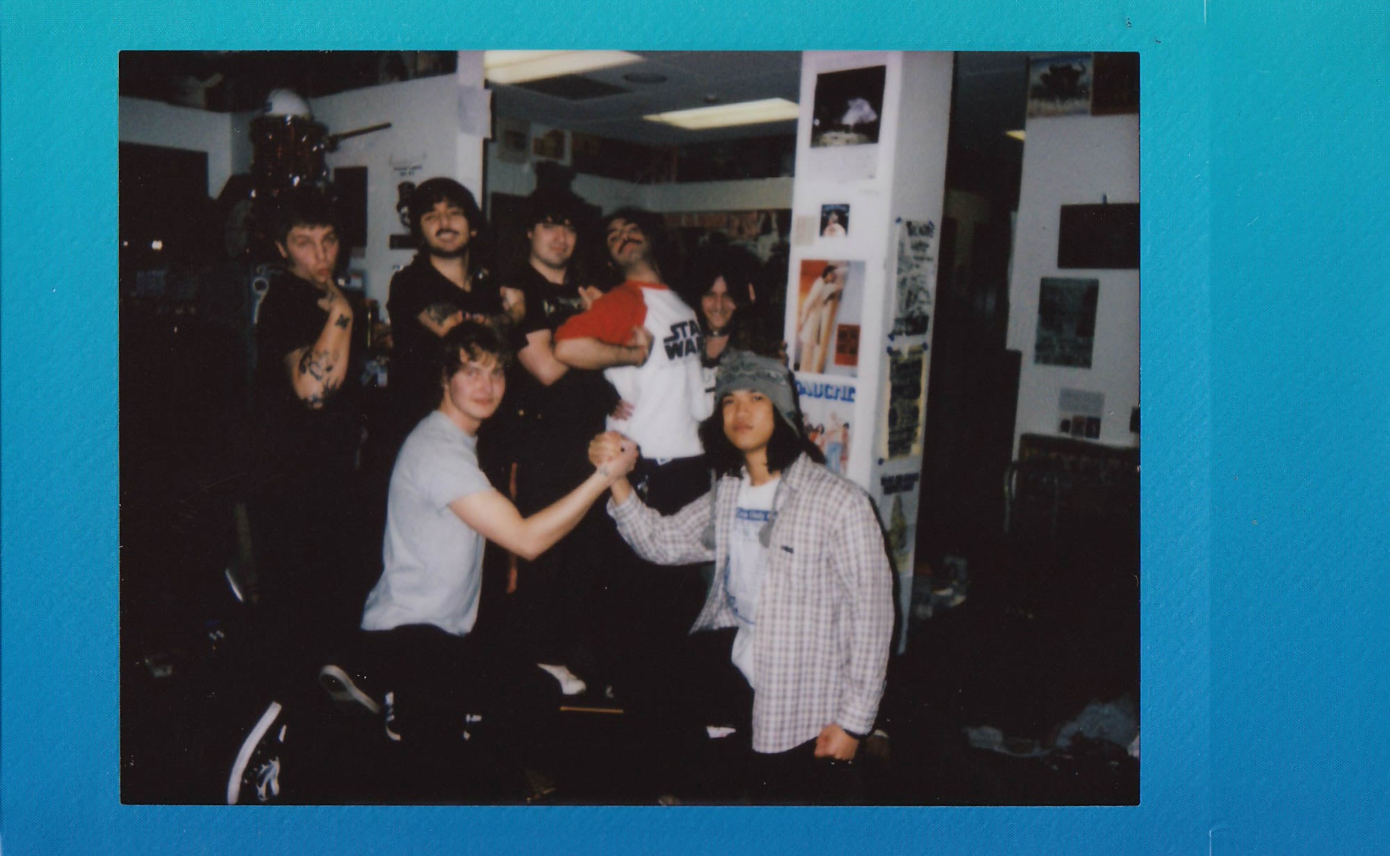 Instant photograph, blue border, with 7 people posing in KWVA radio station