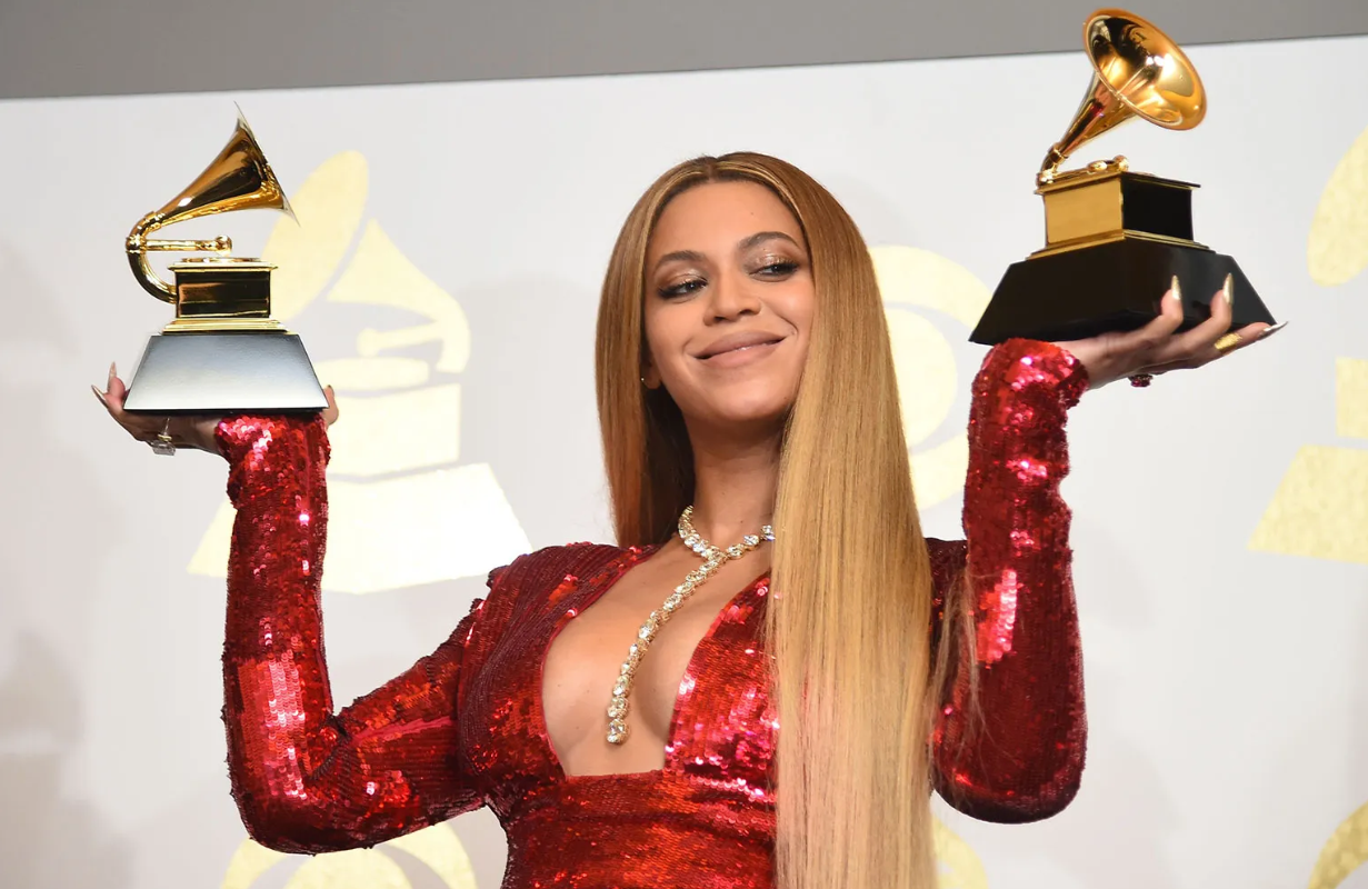 A picture of Beyonce holding two Grammy awards.