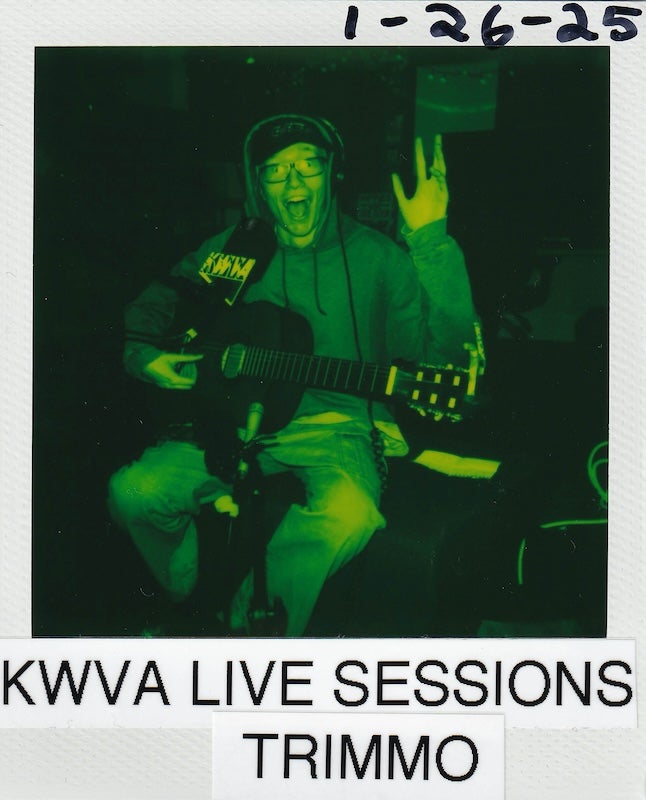 Polaroid picture with dark green filter, Trimmo, early 20's white male with glasses holding guitar. Text reads january 26th 2025, kwva live sessions, trimmo.