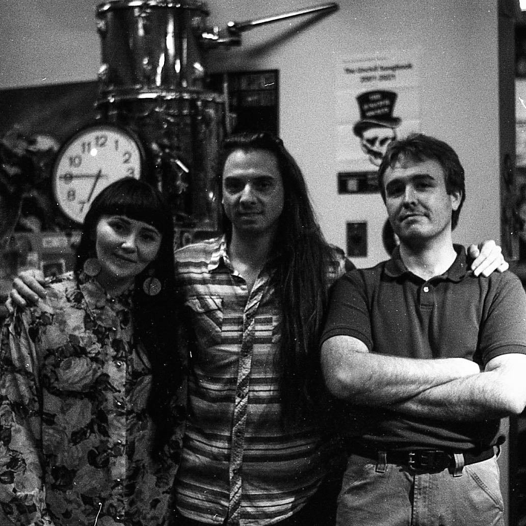 Three musicians, white female, white male, white male, posing in KWVA studios