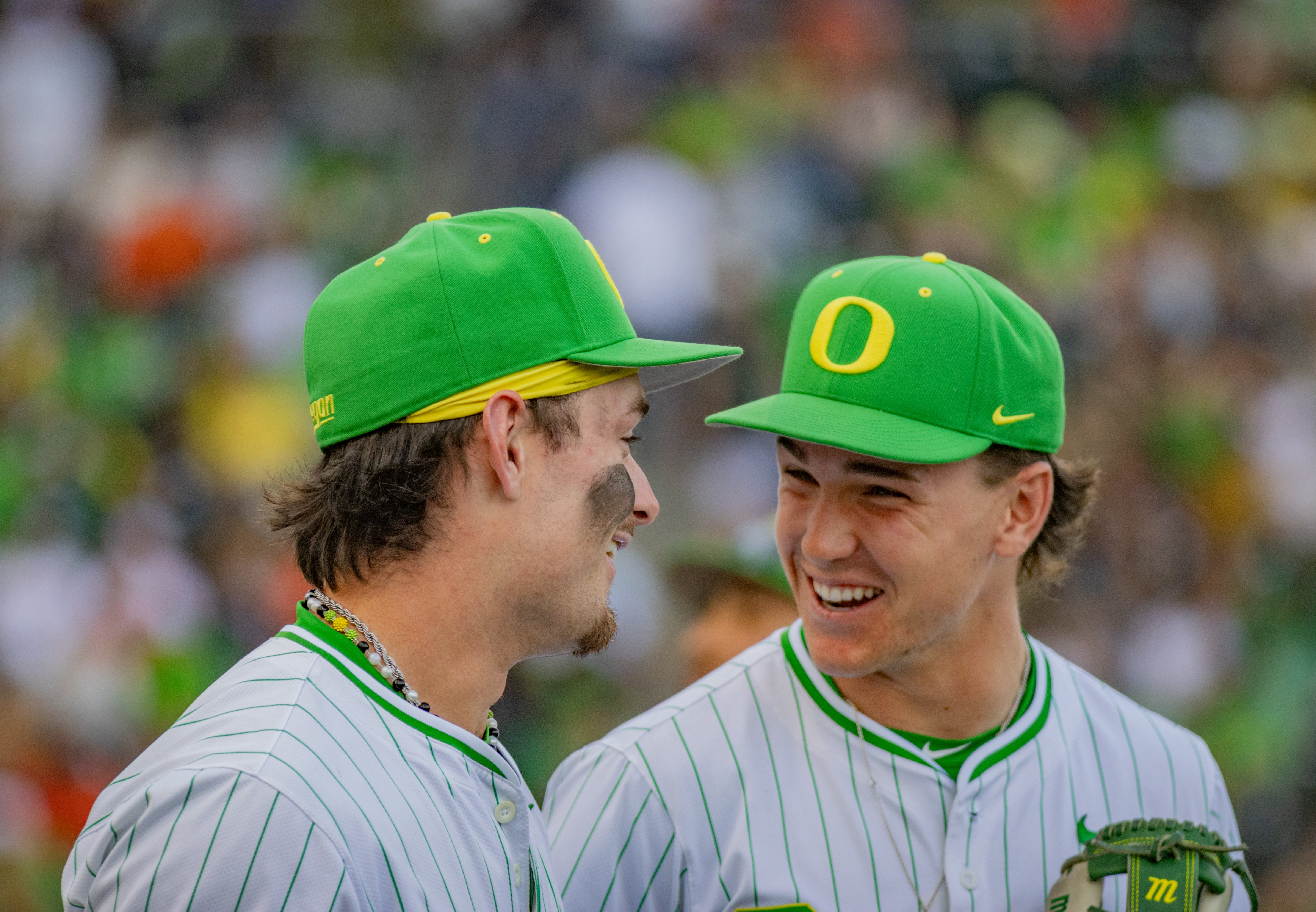 Members of the Oregon baseball team smile in the outfield during their victory over Oregon State on April26, 2025.