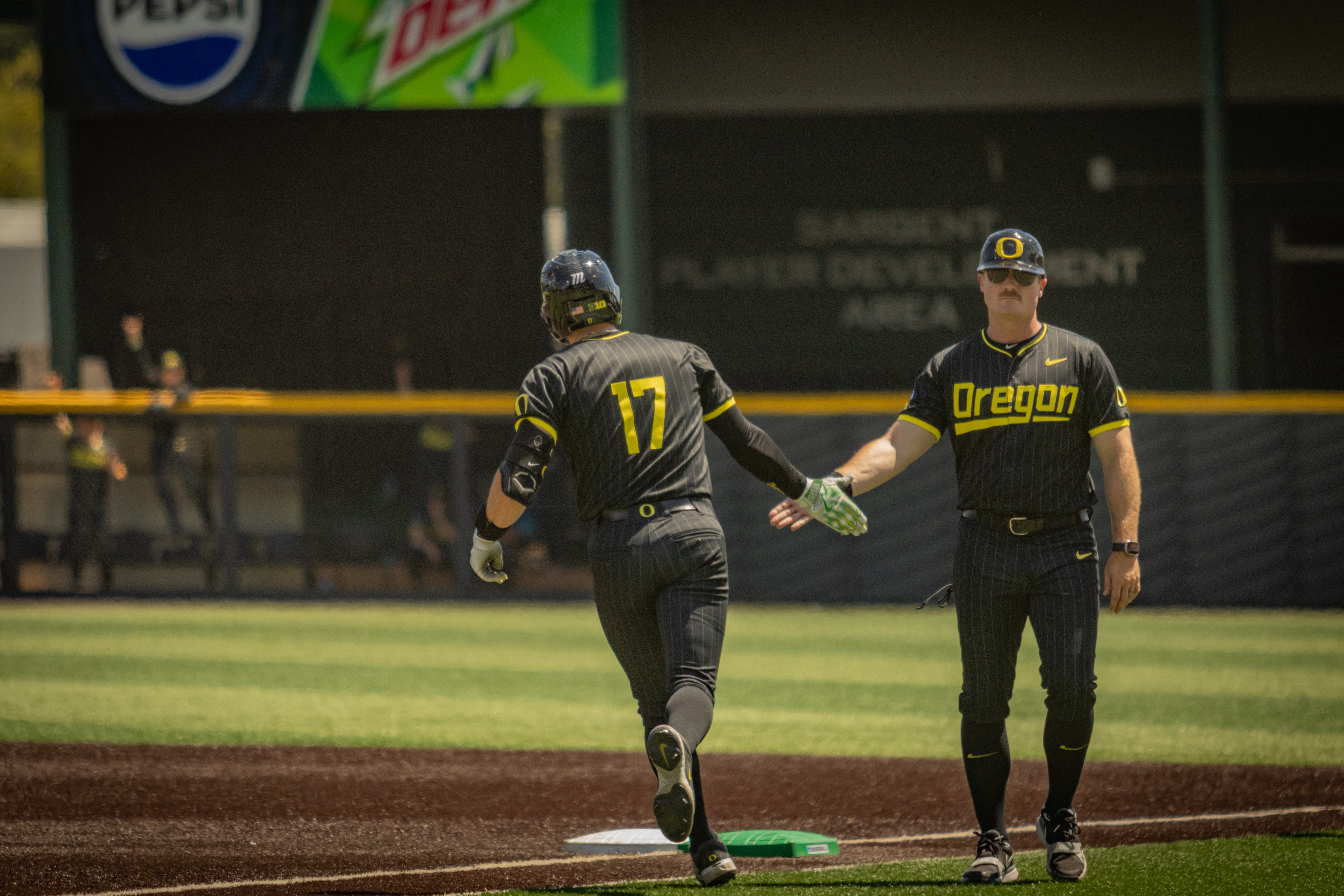 Drew Smith high five's his Oregon baseball teammate during the Ducks' season-ending loss on May 31, 2025.