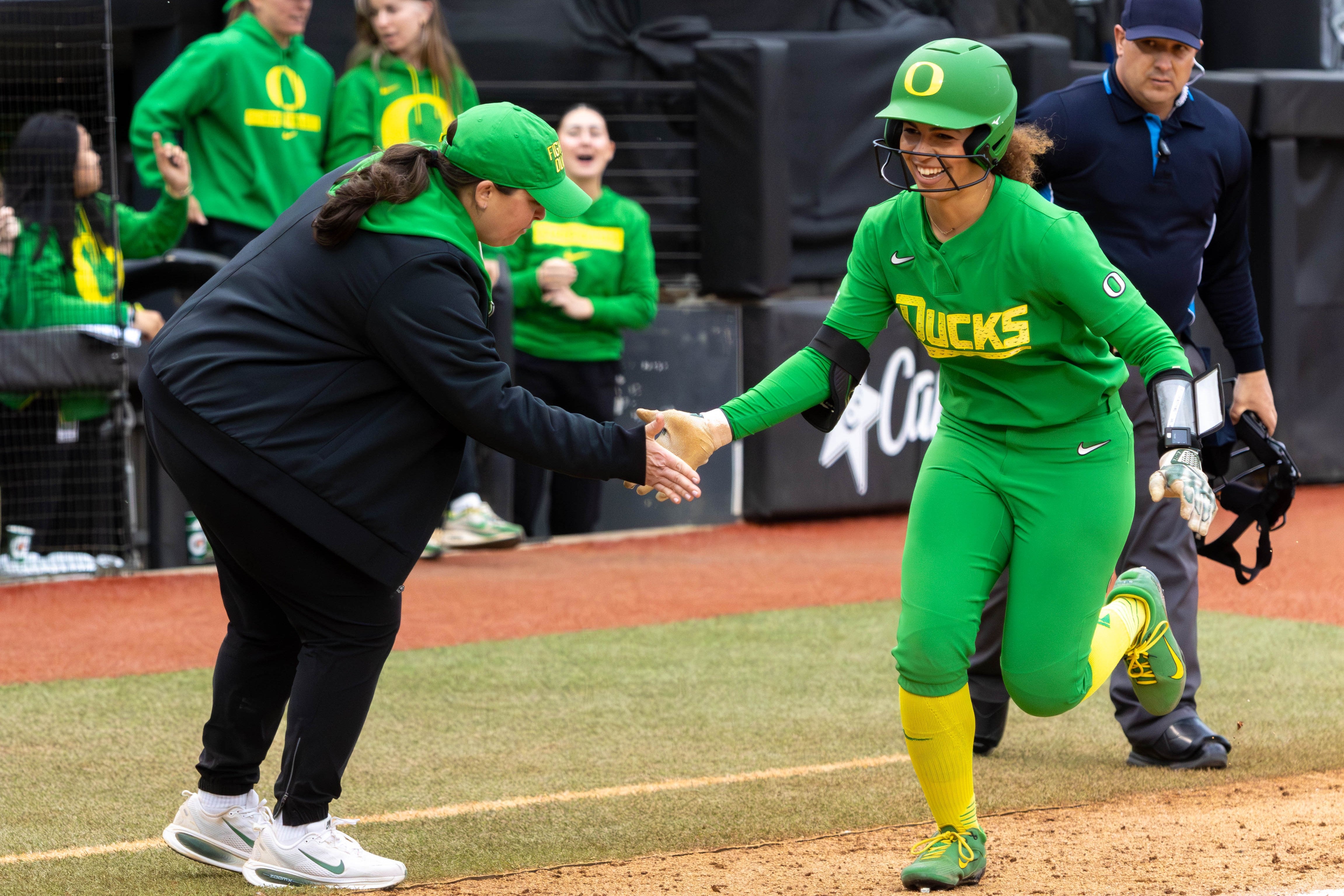 Oregon's Amari Harper high-fives third-base coach Sam Marder as she rounds third after a two-run homer against Oregon State