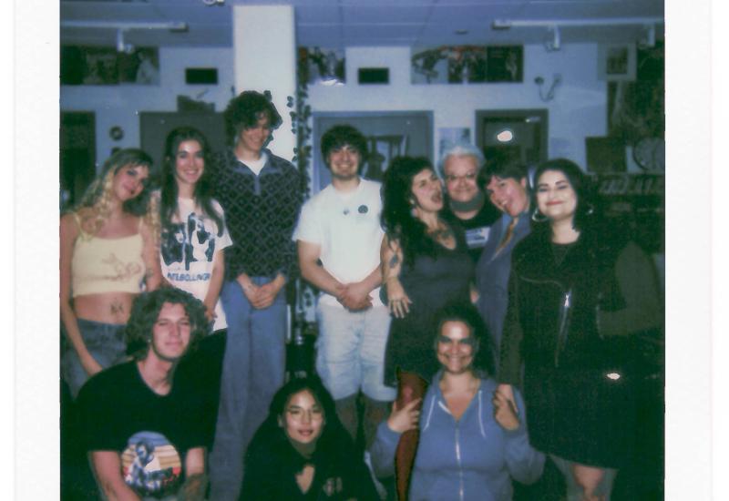 Polaroid photo reading "KWVA LIVE SESSIONS GRRRLZ ROCK 2024 11-24-24" with 11 people posing together