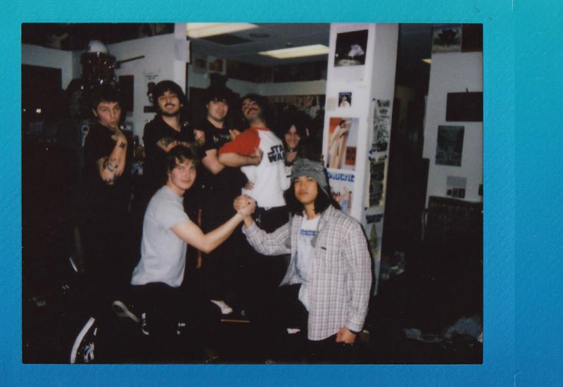 Instant photograph, blue border, with 7 people posing in KWVA radio station