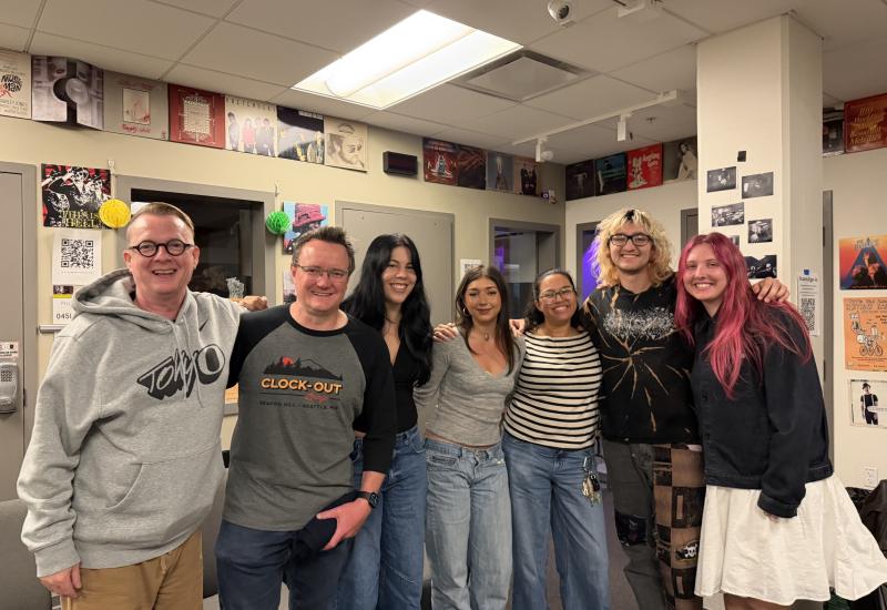 Photo: KWVA alumni and current student staff during their October 2026 visit. From left: John Thomas, Bill Trinen, Sam Polis (Music Director), Chloe Baldwin (Office Assistant), Carole Ann Balkcom (Assistant Music/Blog Director), Niko Paroissien-Arce (Production Coordinator), and Hannah Bard (News Director).Photo by Charlotte Nisser Allen / KWVA.